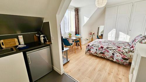 une petite chambre avec un lit et une table dans l'établissement Studio Lavande - 15min Paris RER E, cosy, à Noisy-le-Sec