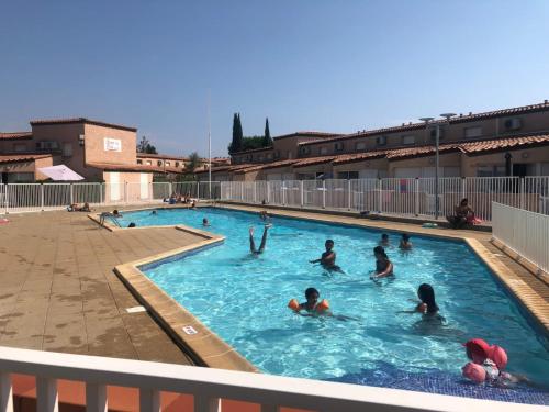 un groupe de personnes jouant dans une piscine dans l'établissement T2 Pierres de Jade avec piscine, à Saint-Cyprien