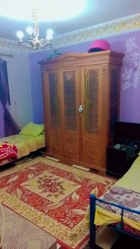 a room with a wooden cabinet and a rug at الخريطه هاوس in Tall al Misţāḩ