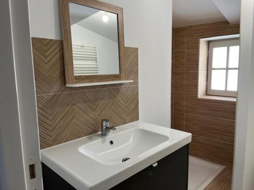 une salle de bain avec un lavabo blanc et un miroir dans l'établissement Studio dans un immeuble historique, à Martigues