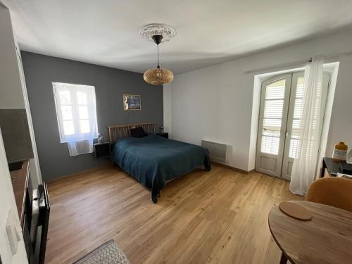 une chambre avec un lit et un parquet dans l'établissement Studio dans un immeuble historique, à Martigues