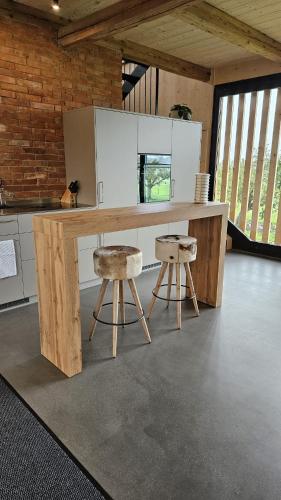 a kitchen with a wooden table and two stools at Salzhaus in Amsoldingen