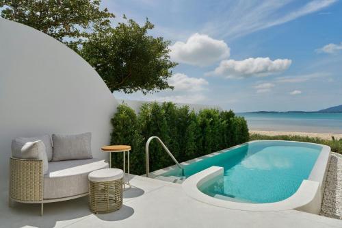 a patio with a swimming pool and a chair at Veranda Resort Phuket, Autograph Collection in Panwa Beach