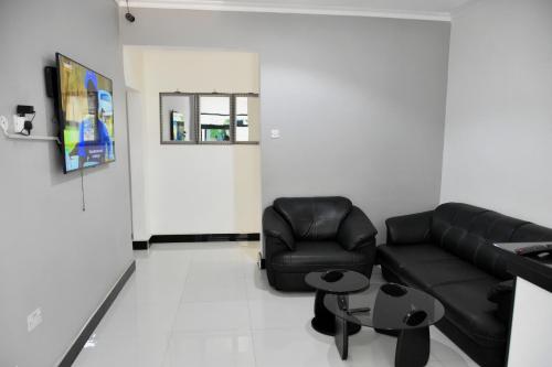 a living room with a black couch and a table at Alexandrina's Corner in Chipata