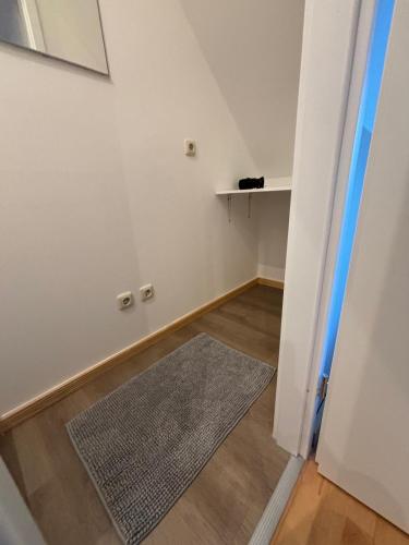an empty room with a rug and a white wall at Doppelzimmer-Bad-Kühlschrank TV-18 in Meine