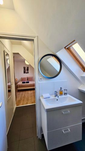 une salle de bain avec un lavabo et un miroir dans l'établissement Studio Pavot - 15min Paris RER E, cosy, à Noisy-le-Sec