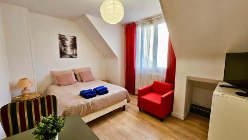 a bedroom with a bed and a red chair at Studio Pavot - 15min Paris RER E, cosy in Noisy-le-Sec