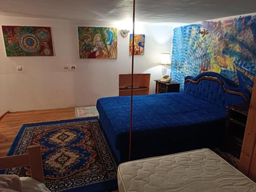 a bedroom with a blue bed and a rug at Atelje duplex in Žarkovo