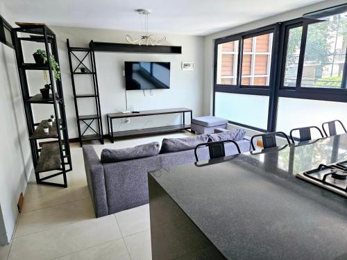 a living room with a couch and a tv at Singular Sócrates in Mexico City