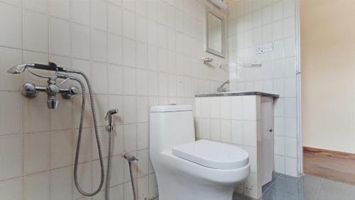 un baño con inodoro y ducha en Fruitsnbeans Homestay Kodaikanal, en Kodaikanal