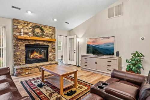 een woonkamer met een bank en een open haard bij Peaceful Mtn View- Hot Tub- Fire Pit- Pets- Pond in Sevierville