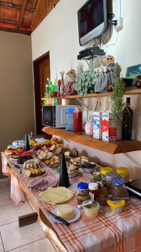 una tavola piena di cibo sopra a un tavolo di Pousada Arco Iris a Gonçalves