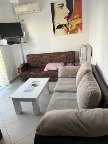 a living room with a couch and a coffee table at Sea flavor in Shëngjin