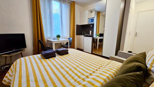 Una habitación de hotel con una cama con toallas. en Studio Safran - 15min Paris, calme & cosy, en Noisy-le-Sec