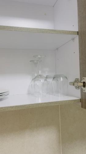 a row of wine glasses sitting on a shelf at Nala Realty at The Aura in Sandton
