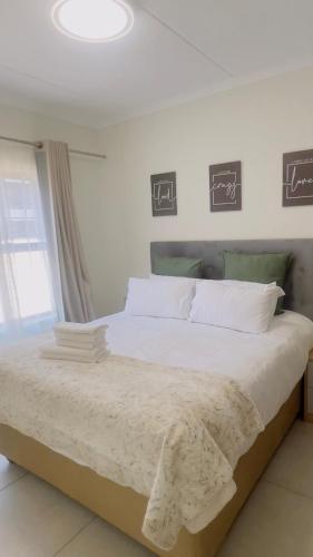 a bedroom with a large bed with white sheets at Nala Realty at The Aura in Sandton