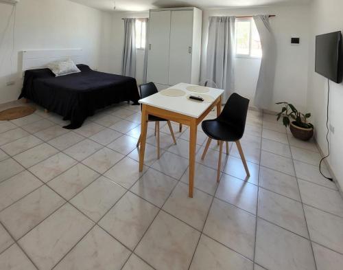 a room with a bed and a table and chairs at Alojamiento Cerro de la Cruz in San Luis
