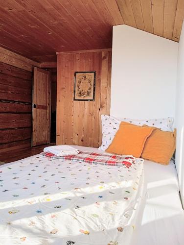 a bed in a room with a wooden ceiling at Sérénité Spiez, Lakeview, Chalet in Einigen