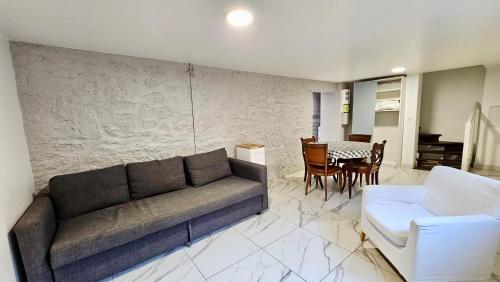 a living room with a couch and a table at Appartement Attica - 15min Paris RER E, cosy in Noisy-le-Sec