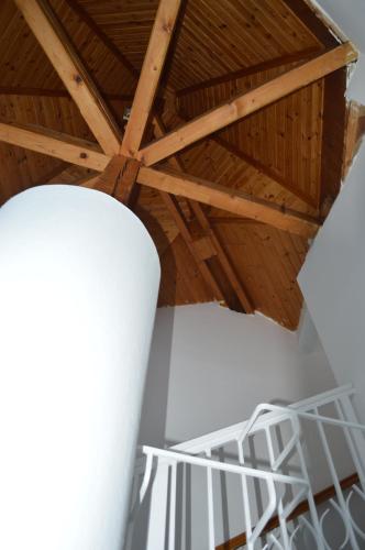 a room with a wooden ceiling and a white shelf at Valentin ház in Szentendre