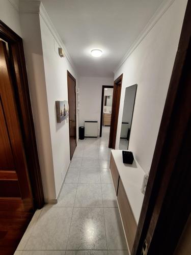 a hallway with white walls and a tile floor at Alquiler Vacacional PC in Noya