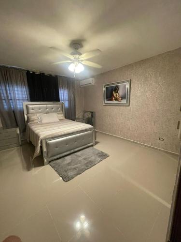 a bedroom with a bed and a tv on the wall at Apartment in Harmony I in Santiago de los Caballeros