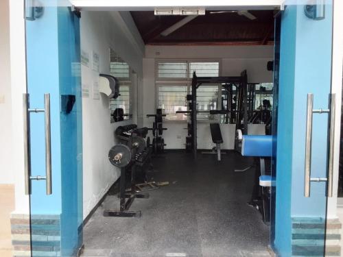 a gym with several treadmills and machines at Apartment in Harmony I in Santiago de los Caballeros
