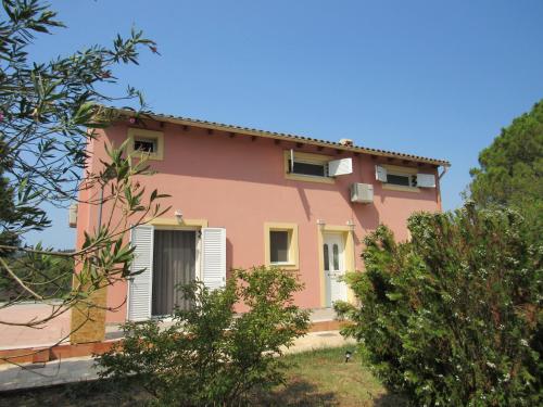 a pink house with trees in front of it at Catherine's maisonette in Corfu Town
