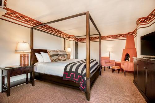 a bedroom with a canopy bed and a television at Inn & Spa at Loretto in Santa Fe