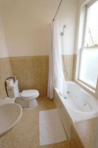 a bathroom with a tub and a toilet and a sink at Above Maxwell Wine Bar - Super Central 2Bed 2Bath in Washington, D.C.