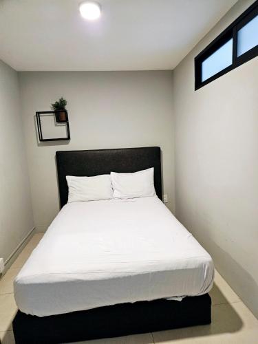 a bedroom with a white bed with a black headboard at Singular Sócrates in Mexico City