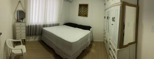 ein Schlafzimmer mit einem Bett, einer Kommode und einem Spiegel in der Unterkunft Vivendas do Rio 1 in Ananindeua