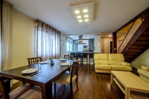 une salle à manger et un salon avec une table et des chaises dans l'établissement Superbe Duplex Cosy Parking Hypercentre, à Villeurbanne