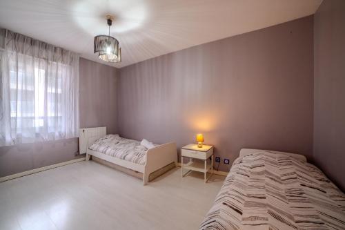 une chambre avec deux lits et une table et une fenêtre dans l'établissement Superbe Duplex Cosy Parking Hypercentre, à Villeurbanne