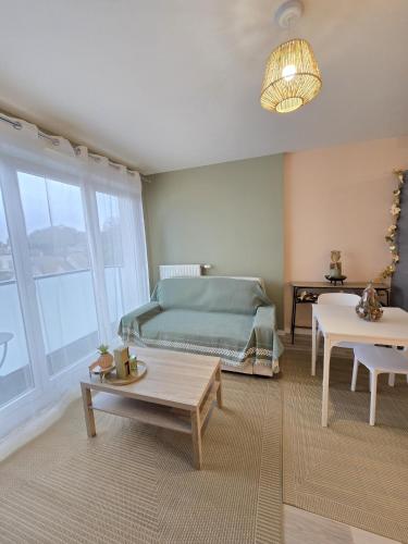 un salon avec un lit et une table dans l'établissement Proche Paris et Disneyland, à Champigny-sur-Marne