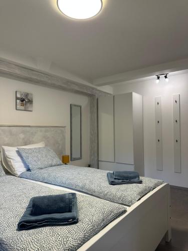a white bedroom with two beds with towels on them at Apartment Bilić in Pula