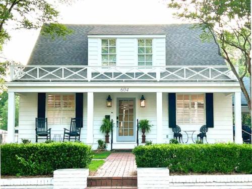 a white house with black chairs in front of it at The Eakes House on South 8th in Oxford