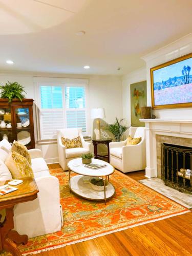 a living room with white furniture and a fireplace at The Eakes House on South 8th in Oxford