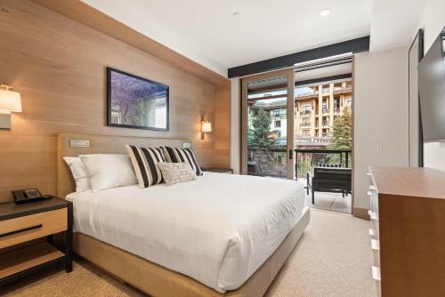 a bedroom with a bed and a desk and a window at Snowmass Lux Getaway by Snowmass Vacations in Snowmass Village