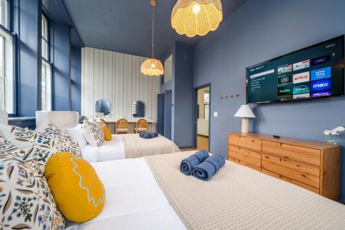 a bedroom with two beds and a tv on the wall at SchoolHouse now Lux BNB! Gym, Sauna, HotTub, GameRoom in Union Pier