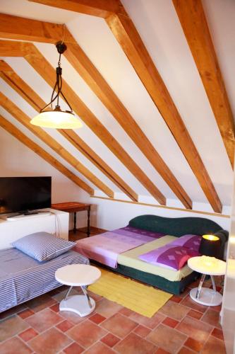 a attic bedroom with a bed and two tables at Apartments AstaLaVIsta in Okrug Donji