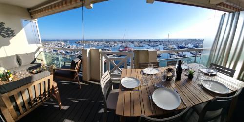 une table sur un balcon avec vue sur un port dans l'établissement Face à la mer en première ligne pour 6 personnes avec Ménage Linge et Wifi, à Arcachon