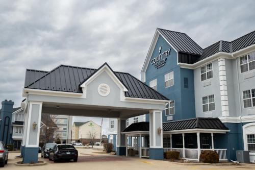 a large blue and white hotel with a parking lot at Country Inn & Suites by Radisson, Effingham, IL in Effingham