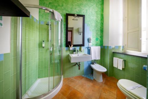 a green bathroom with a sink and a toilet at Relais Villa Buonanno in Cercola