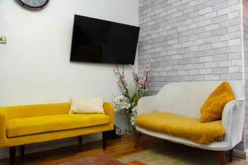 a living room with a yellow couch and a tv at House near Cardiff City Centre in Cardiff