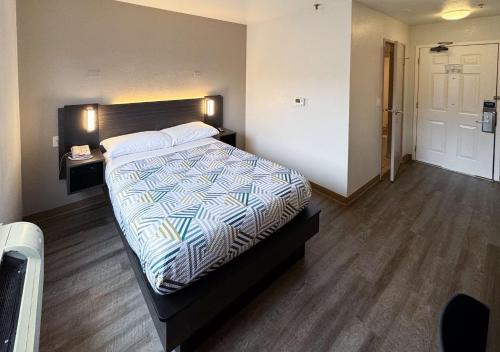 a bedroom with a large bed with a wooden floor at Motel 6-Glenview, IL - Chicago North in Glenview