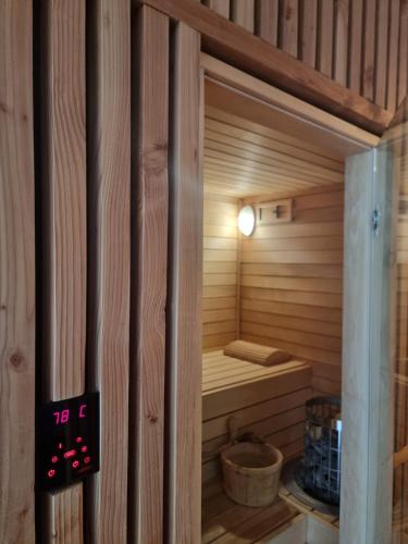 un sauna en bois avec une horloge sur le mur dans l'établissement L ABRI spa et détente, à Liergues