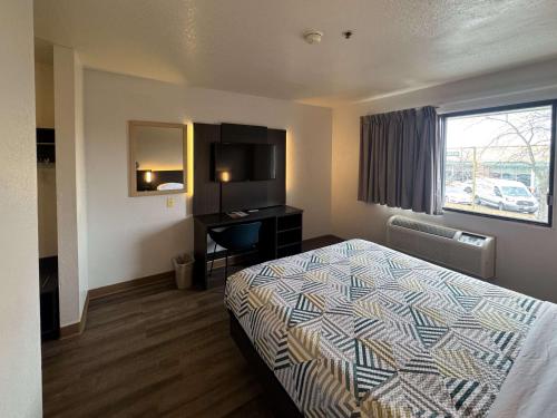 a hotel room with a bed and a desk at Motel 6-Glenview, IL - Chicago North in Glenview