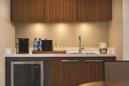 a kitchen counter with a sink and a microwave at Coast Edmonton Plaza Hotel by APA in Edmonton