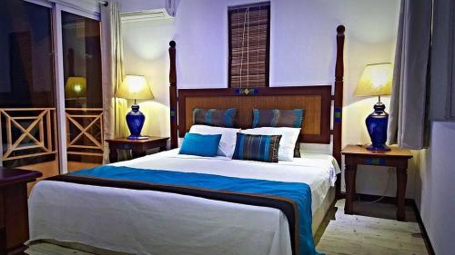 グランベにあるOcean Villas Apart Hotelの大きなベッドと2つのランプがある寝室